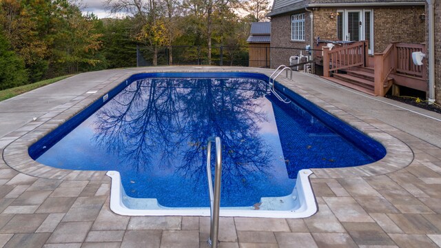 view of swimming pool with a patio and a deck