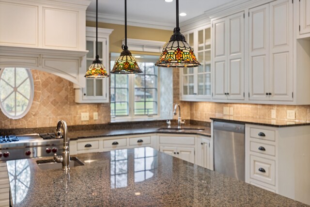 kitchen featuring white cabinetry, stainless steel dishwasher, and dark stone countertops