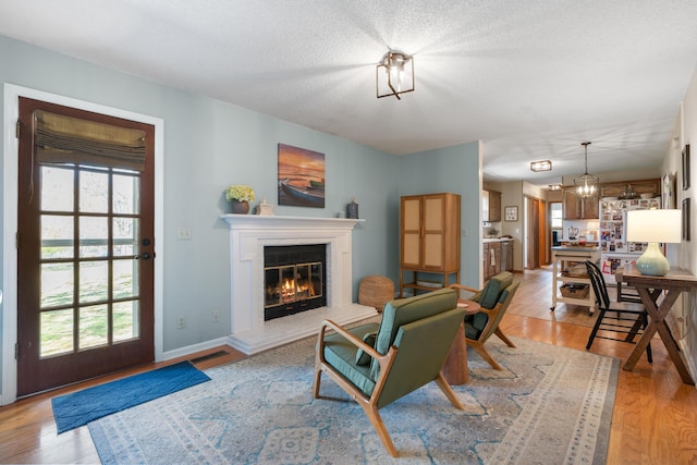 180 Mapleton Forest Dr NW, Cleveland, TN 37312 - living area featuring a glass covered fireplace, plenty of natural light, light wood-style floors, and a chandelier