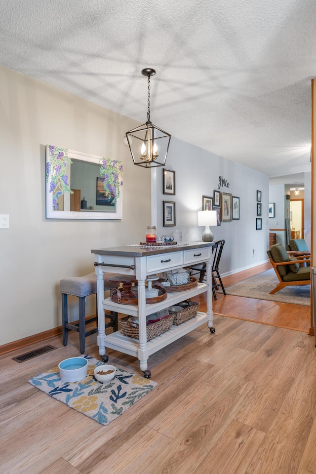 180 Mapleton Forest Dr NW, Cleveland, TN 37312 - dining area with wood finished floors, a chandelier, and a textured ceiling