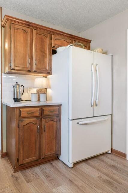 180 Mapleton Forest Dr NW, Cleveland, TN 37312 - kitchen featuring freestanding refrigerator, light wood-style floors, light countertops, and a textured ceiling