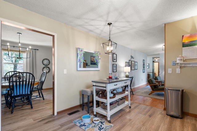 180 Mapleton Forest Dr NW, Cleveland, TN 37312 - dining room featuring a chandelier, light wood-style floors, and a textured ceiling