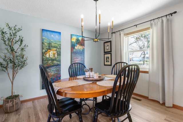 180 Mapleton Forest Dr NW, Cleveland, TN 37312 - dining room with light wood-type flooring, a chandelier, and a textured ceiling