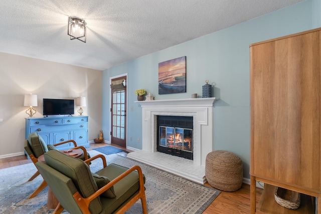 180 Mapleton Forest Dr NW, Cleveland, TN 37312 - living room with wood finished floors, a textured ceiling, and a glass covered fireplace