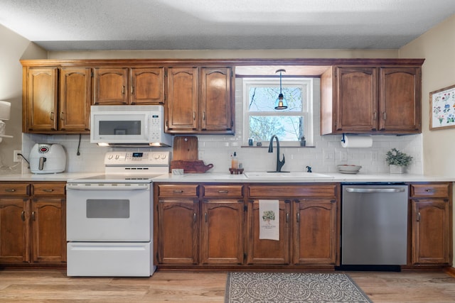 180 Mapleton Forest Dr NW, Cleveland, TN 37312 - kitchen with white appliances, light wood-style flooring, light countertops, tasteful backsplash, and decorative light fixtures