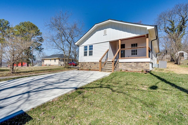 view of front of house with board and batten siding, a front yard, concrete driveway, and a porch