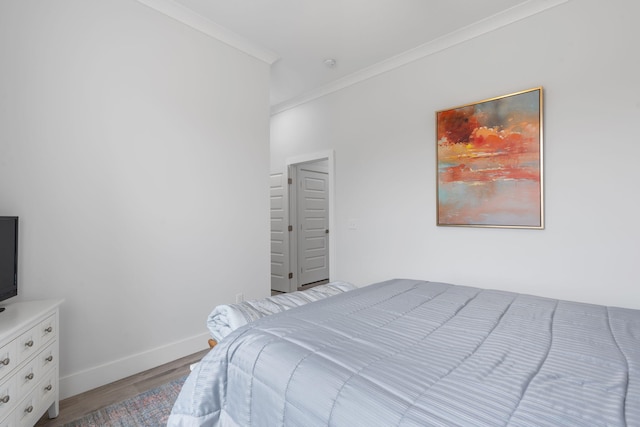 bedroom featuring crown molding and light hardwood / wood-style floors