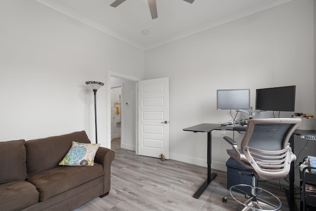 home office with ceiling fan, light hardwood / wood-style floors, ornamental molding, and a towering ceiling