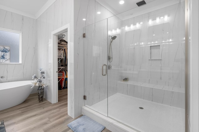 bathroom featuring plus walk in shower, wood-type flooring, and ornamental molding