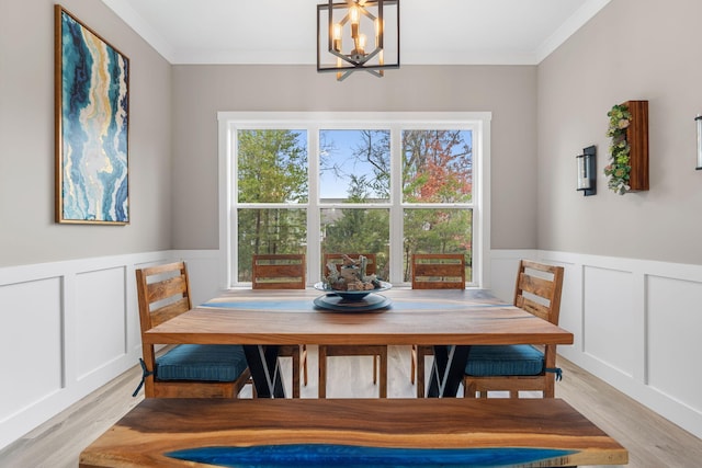 dining area featuring light hardwood / wood-style flooring, a chandelier, and ornamental molding