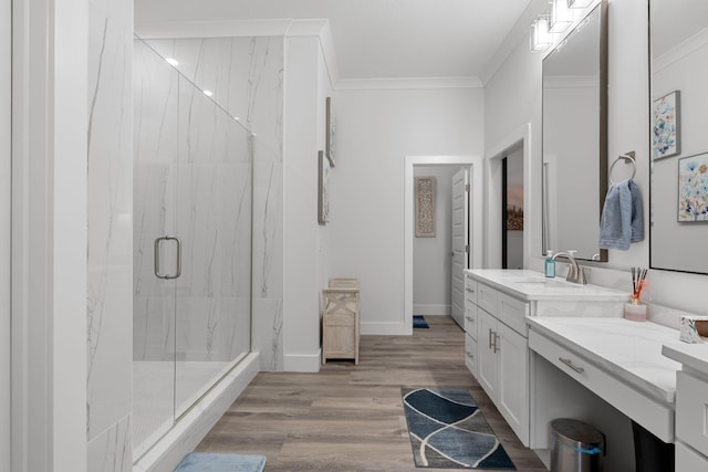 bathroom with crown molding, vanity, wood-type flooring, and an enclosed shower