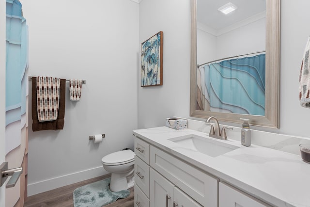 bathroom featuring vanity, hardwood / wood-style flooring, toilet, ornamental molding, and curtained shower