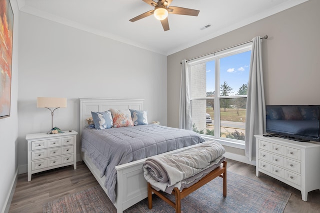 bedroom with ceiling fan, ornamental molding, dark wood-type flooring, and multiple windows