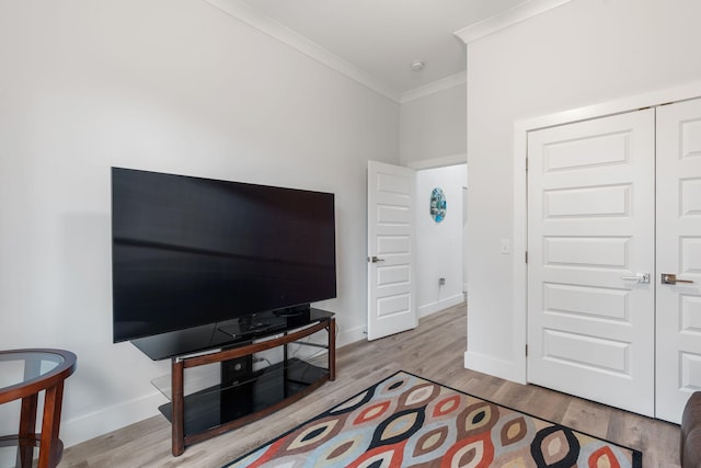 living room with crown molding and light hardwood / wood-style floors