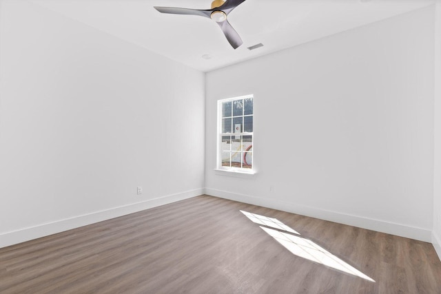 spare room with baseboards, a ceiling fan, and wood finished floors