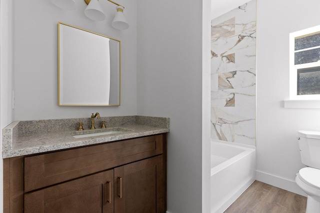 bathroom featuring toilet, shower / bath combination, wood finished floors, vanity, and baseboards