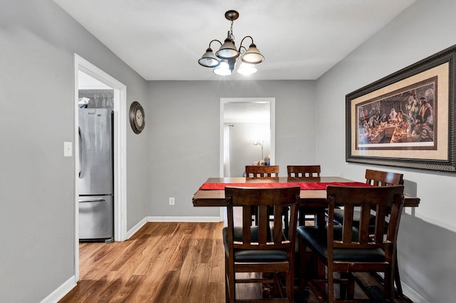 dining space with an inviting chandelier and wood-type flooring