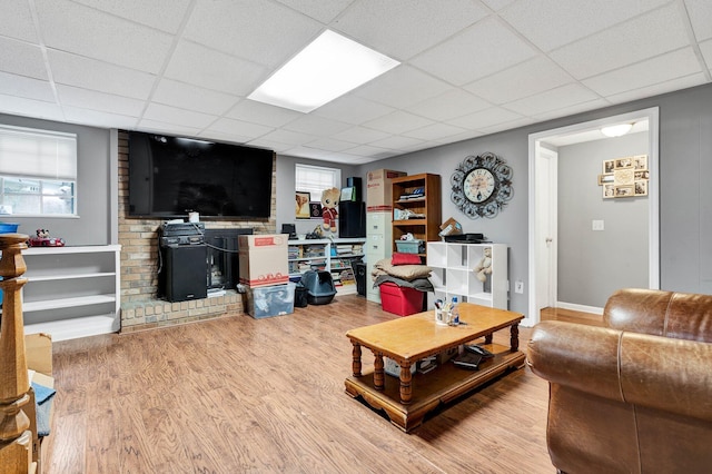 living room with hardwood / wood-style flooring, a paneled ceiling, and a wealth of natural light