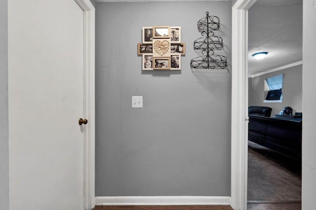 corridor featuring crown molding and a textured ceiling