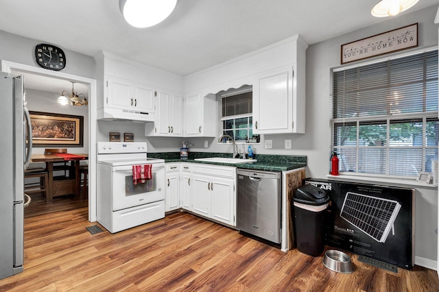 kitchen featuring sink, white cabinets, stainless steel appliances, an inviting chandelier, and light hardwood / wood-style flooring