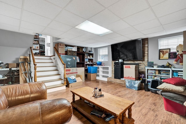 living room with a drop ceiling, hardwood / wood-style floors, and plenty of natural light