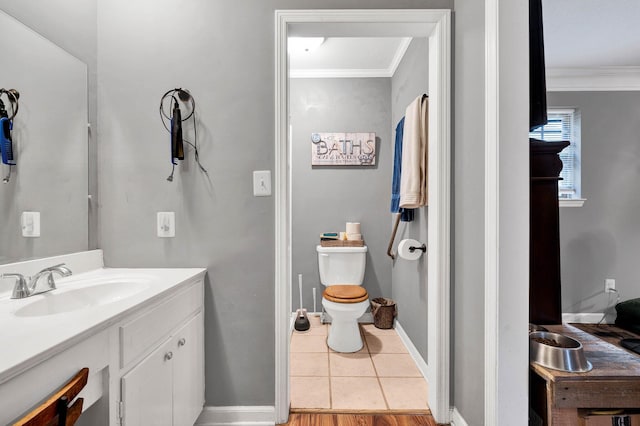 bathroom featuring crown molding, vanity, tile patterned floors, and toilet