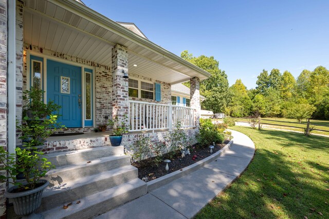 entrance to property with a yard and a porch