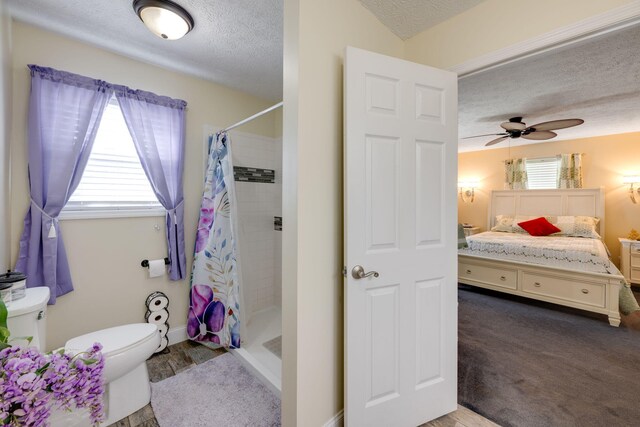 bathroom with curtained shower, ceiling fan, a textured ceiling, and toilet