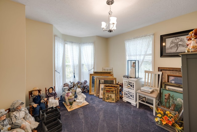 playroom featuring carpet flooring, plenty of natural light, a textured ceiling, and a chandelier