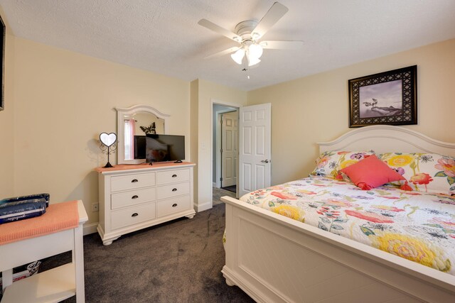 carpeted bedroom with ceiling fan and a textured ceiling