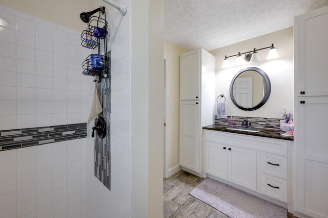 bathroom with hardwood / wood-style floors, vanity, and a textured ceiling