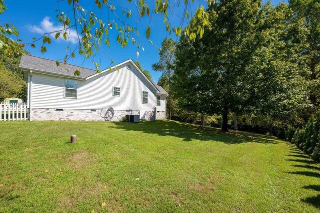 rear view of property featuring central AC and a yard