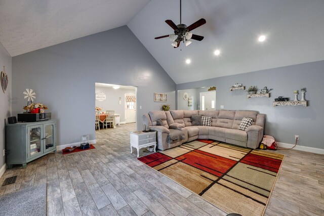 living room featuring ceiling fan, hardwood / wood-style floors, and high vaulted ceiling