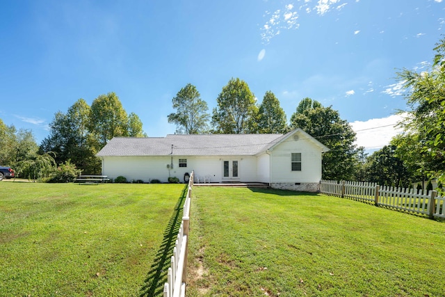 rear view of property with french doors and a lawn