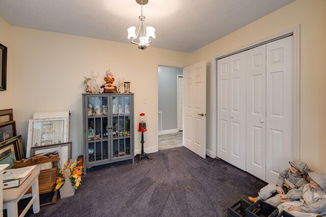 misc room with dark carpet and an inviting chandelier