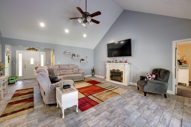 living room with ceiling fan, high vaulted ceiling, and light hardwood / wood-style floors