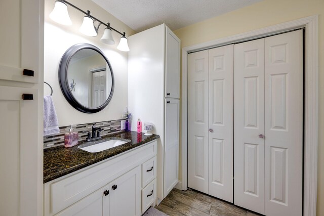 bathroom with vanity, wood-type flooring, and a textured ceiling