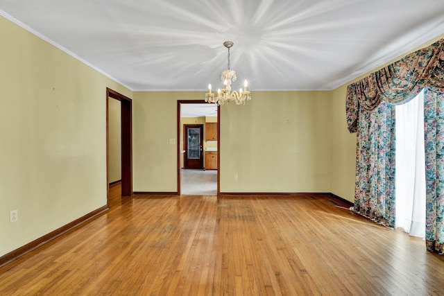 2408 Peerless Rd NW, Cleveland, TN 37311 - spare room featuring light wood finished floors, baseboards, an inviting chandelier, and ornamental molding