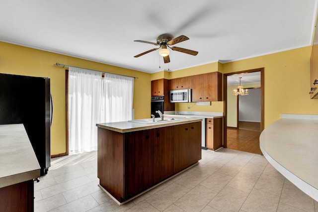 2408 Peerless Rd NW, Cleveland, TN 37311 - kitchen featuring a sink, light countertops, ceiling fan with notable chandelier, stainless steel appliances, and a kitchen island with sink