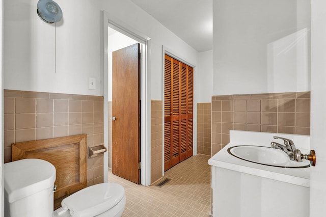 2408 Peerless Rd NW, Cleveland, TN 37311 - bathroom with toilet, tile walls, wainscoting, tile patterned flooring, and vanity