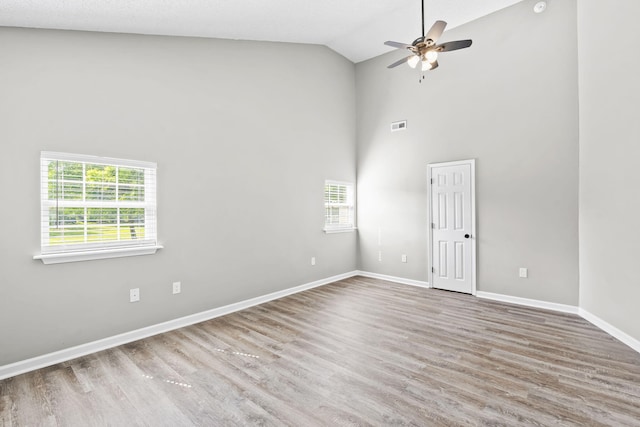 spare room with hardwood / wood-style flooring, ceiling fan, and high vaulted ceiling