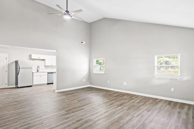 unfurnished living room with ceiling fan, light hardwood / wood-style floors, a healthy amount of sunlight, and sink