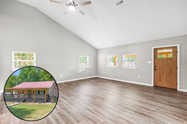 unfurnished living room featuring hardwood / wood-style flooring, vaulted ceiling, and ceiling fan