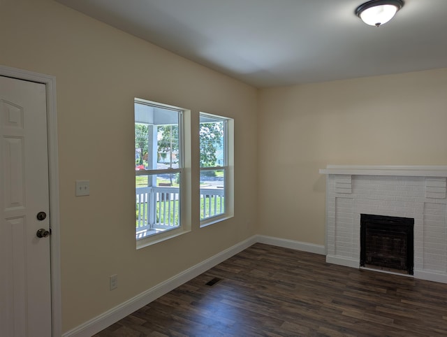 2811 E 26th St, Chattanooga, TN 37407 - unfurnished living room with healthy amount of natural light, dark wood finished floors, baseboards, and a fireplace