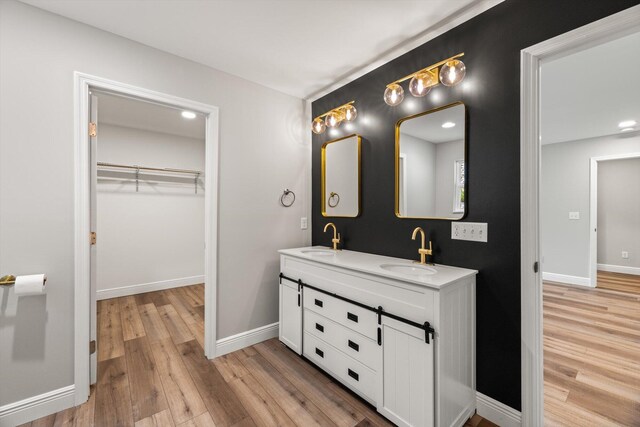 1523 Eads Bluff Rd NW, Georgetown, TN 37336 - bathroom with wood finished floors, double vanity, a spacious closet, baseboards, and recessed lighting