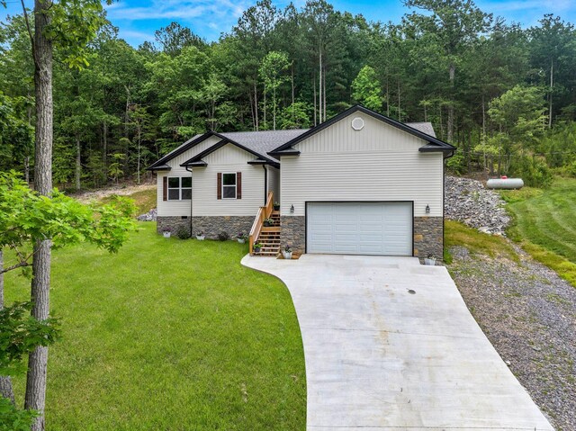 1523 Eads Bluff Rd NW, Georgetown, TN 37336 - view of front facade with driveway, a front lawn, stone siding, a forest view, and an attached garage
