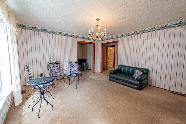 sitting room with visible vents, carpet, a chandelier, and wallpapered walls