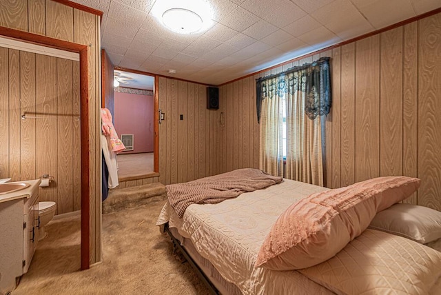 carpeted bedroom featuring wood walls