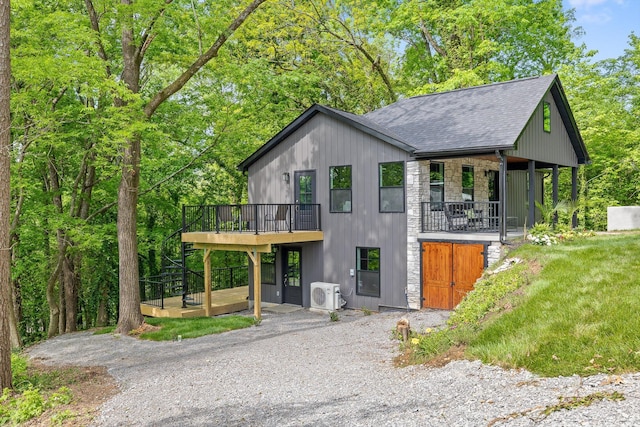 view of front of property with stone siding, ac unit, roof with shingles, and a deck