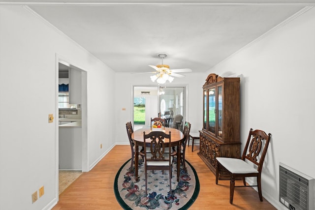 dining space featuring ceiling fan, light hardwood / wood-style floors, ornamental molding, and heating unit